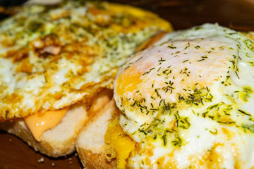 Sandwiches made of wheat bread, sauce and fried eggs with dill. Close up.