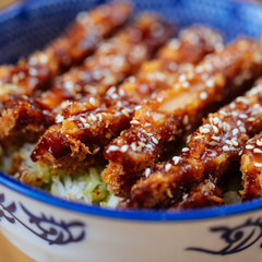 Closeup on asian japanese dish fried chicken with katsudon rice in a traditional blue bowl