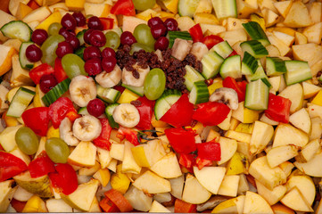 Bright variety of cut fruits and vegetables. Vitamin diversity for healthy eating.