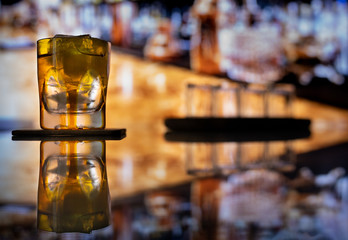 Whiskey with ice or brandy in a glass on a bar tap in a traditional style pub. Whiskey with ice in a glass.