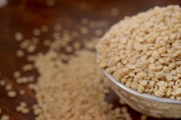 Split White Urad Dal. Vigna mungo Beans  in a Silver bowl on wooden old Table. Rustic style 