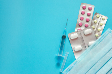 Pills, syringe, medical mask with copy space, flat lay. Pharmacy business and financial...