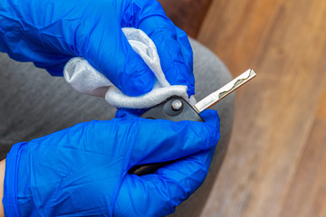 cleaning, disinfecting, wiping auto keys panel with a hand in glove and napkin close up