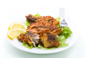 fried hake fish in batter with lettuce and lemon in a plate