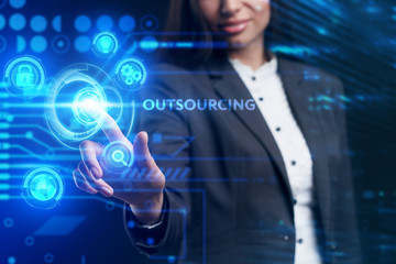 Business, Technology, Internet and network concept. Young businessman working on a virtual screen of the future and sees the inscription: Outsourcing