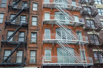 Fototapeta na wymiar Typical New York City Apartments with Fire Escape Ladders