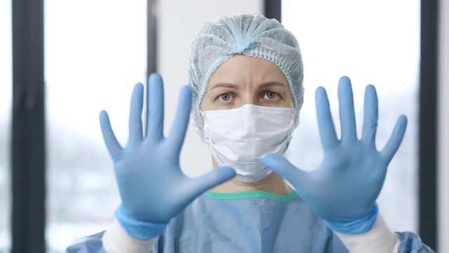Doctor in uniform adjusting protective medical sterilized gloves before medical checkup.  Portrait of a doctor or nurse in uniform. 