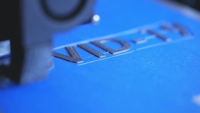 Slow motion of a 3D printer printing COVID19 words.