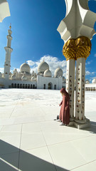 The Sheik Zahed Grand Mosque in Abu Dhabi with a beautiful women in front