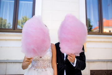 Beautiful wedding couple have a special time together, they posing with pink Cotton Candy