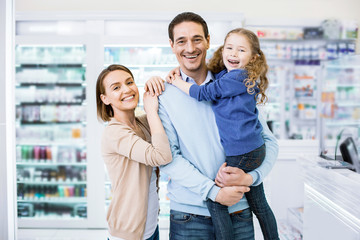 Cheerful glad family posing in drugstore and looking happy