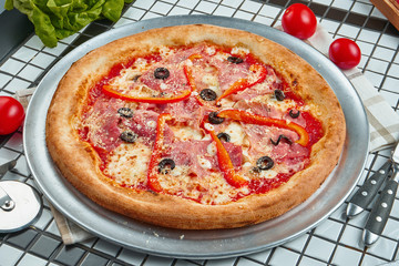 Pizza with a large number of toppings: salami, bell pepper, olive, cheese. Pizza in composition with ingredients on a white background. Food flat lay