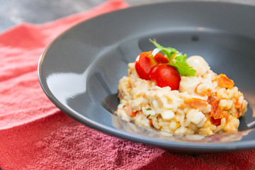 Tasty risotto with Shrimp, fresh herbs vegetables on a white plate