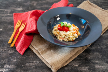 Tasty risotto with Shrimp, fresh herbs vegetables on a white plate