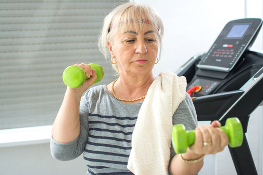 Active Mature Woman Working Out With Dumbbells At Home Gym. Stay At Home, Active Seniors, Home Quarantine, Corona Virus Concept.