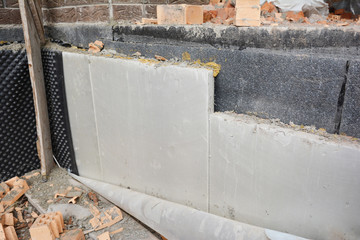 Installing the foundation insulation with rigid extruded polystyrene foam boards for energy...