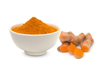 Turmeric powder in a white bowl and turmeric (curcumin) rhizomes isolated on a white background.	