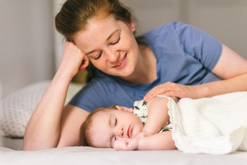 Fototapeta na wymiar How to put a baby to sleep? Nine-month-old baby sleeping in peace with mom