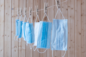 Disposable medical masks hang on a clothesline. Concept. Reuse. Deficit