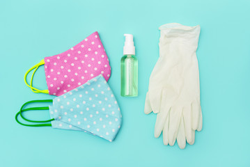 diy fabric face masks. medical gloves and sanitizer in bottle. aqua background