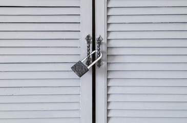 metal lock on the handles of wooden doors with blue bars
