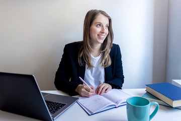 Young entrepreneur woman working at home, writing down business