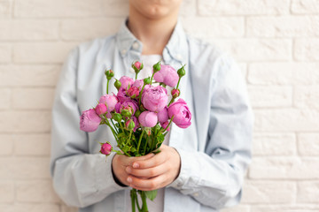 Cute boy holding pink roses bunch flowers for mother. Mother's Day concept
