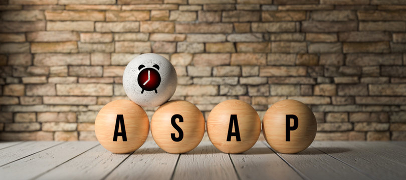 wooden balls with acronym ASAP for AS SOON AS POSSIBLE in front of a brick wall