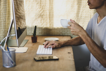 Asian man working from hone online because of covid-19. Work at home and social distancing concept. Selective focus.