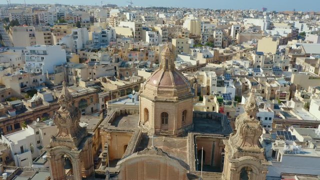 Aerial top view of catholic parish church in Msida city. Sunny day. Camera moves up and turn down. Malta country