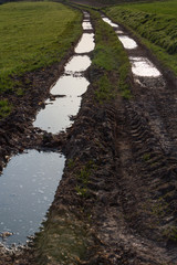 Feldweg mit Matsch und Pfützen