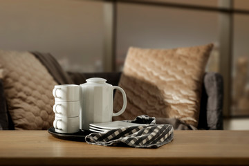 Wooden coffee table of free space for your decoration and blurred window space with sofa and pillows 