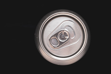 Metal can of soda with water drops on black background. Top view of a aluminum can beer. Metallic container of drink, beverage. Steel round surface.