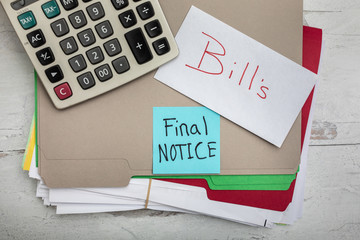 Stacks of payments filling two file folders with posted noted words bills and final notice 