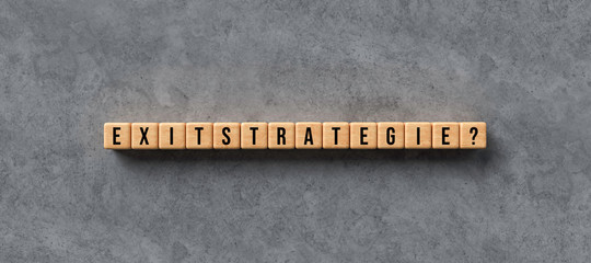 wooden cubes with the German word for EXIT STRATEGY on concrete background