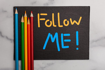 Growing your social media presents Follow Me sign with colorful pencils 