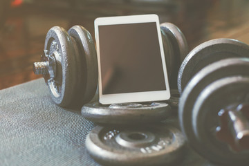 Obraz na płótnie Canvas Online weight training coach by tablet, using only dumbbell at home.