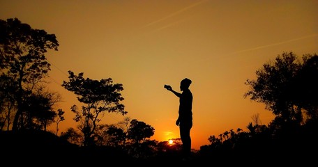 A young man takes a selfie at sunset