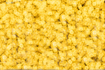 Beautiful luminous golden yellow bokeh patterns, background high resolution image. defocused circles of the open aperture of the lens.