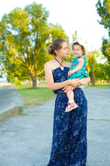 vertical outdoor portrait of a cute one-year-old baby for a walk with mom