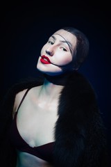 portrait of seductive young woman with stockings on her head against dark background