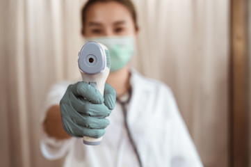 Doctor check patient body temperature using infrared forehead thermometer at hospital for Corona...