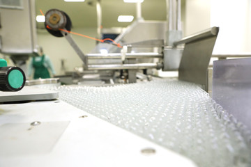 Pharmaceutical industry. Production Line. Machine conveyor with glass bottles, ampoules in a factory. Fill bottles and ampoules for solid particles in liquid and container defects. Pharmaceutical