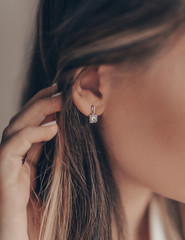 Beautiful elegant silver earring with diamond on close-up - obrazy, fototapety, plakaty