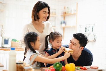 Young Asian love family are preparing cooking the breakfast, sandwich vegetable on table in the...