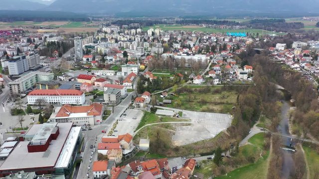 Forward flying drone aerial view of old downtown of Kranj town, Slovenia over green town landscape