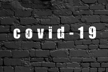 Fototapeta na wymiar Modern black brick wall texture for background with text covid-19 coronavirus pandemia