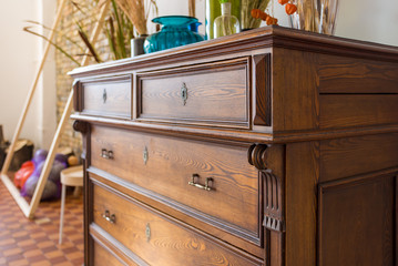old antique old mahogany chest of drawers in a room with additional decor. interesting design