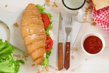 Croissant with tomatoes, cheese and ham not a white background