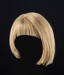 Blond hair female wig isolated on black background - obrazy, fototapety, plakaty